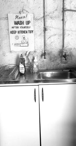 a kitchen counter with a sink and a sign on the wall at Island Cabin in Mpofane