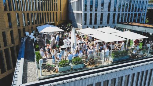 a group of people standing around a restaurant with umbrellas at Clarion Hotel Malmö Live in Malmö