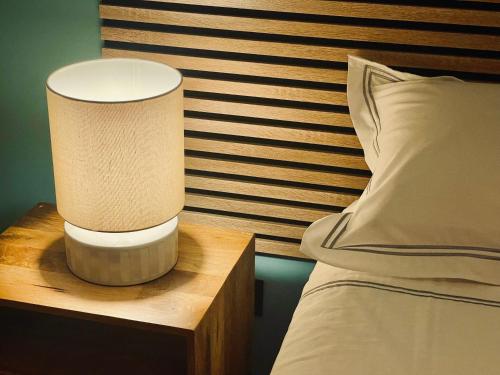 a lamp on a night stand next to a bed at Les Colonnes d'Andrea in Nevers