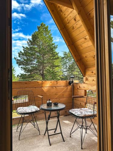 a patio with two chairs and a table on a porch at Planinska Brvnara Zlatni Bor in Nedići