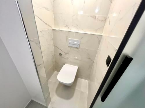 a white bathroom with a toilet in a stall at MT Boutique Suites y Apartamentos - Adults Only - in Mataró
