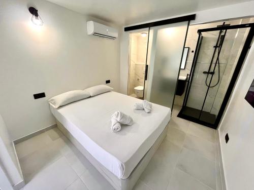 a bedroom with a white bed with towels on it at MT Boutique Suites y Apartamentos - Adults Only - in Mataró