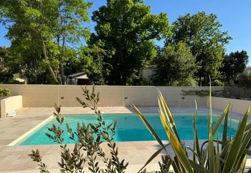une piscine en face d'une clôture dans l'établissement Appartement Uzès, piscine, climatisation, parking privé, à Uzès