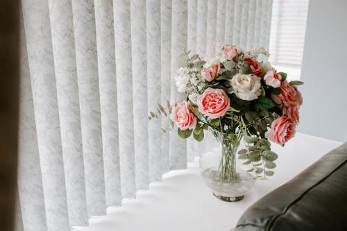 a vase of flowers on a table next to a window at Badger Lane - 3 Bedroom House, parking and garden! in Thornaby on Tees