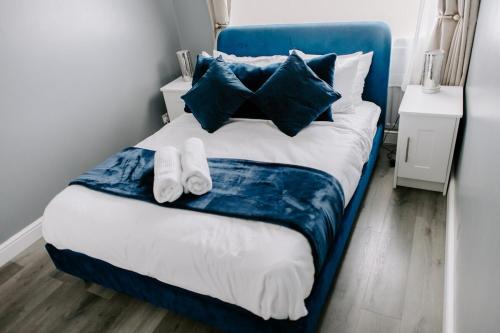 Thornaby on TeesにあるBadger Lane - 3 Bedroom House, parking and garden!の青と白のベッド(タオル2枚付)