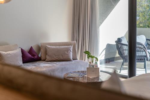 a living room with a couch and a large window at Boutique Hotel AMARIL in Castelbello-ciardes