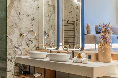 a bathroom with two sinks and a mirror at Boutique Hotel AMARIL in Castelbello-ciardes