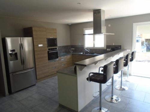- une cuisine avec un réfrigérateur en acier inoxydable et des tabourets dans l'établissement maison 4 chambres, à Baume-les-Dames