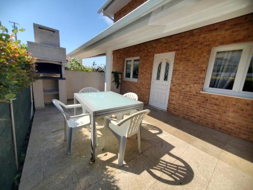 a patio with a table and chairs and a brick building at Casamilia Suite Parentale in Esposende