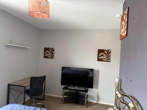 a bedroom with a flat screen tv and a table and chairs at Bettys master bedroom in Stockton-on-Tees
