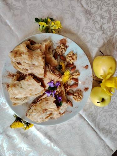 a bowl of food with flowers on a table at Planinska Brvnara Zlatni Bor in Nedići