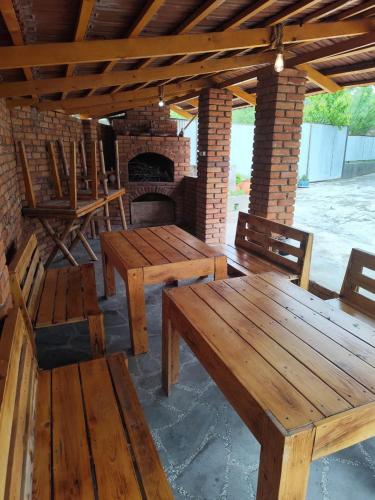 a patio with wooden tables and chairs and a brick oven at Hotel "Red House" in Akhaltsikhe