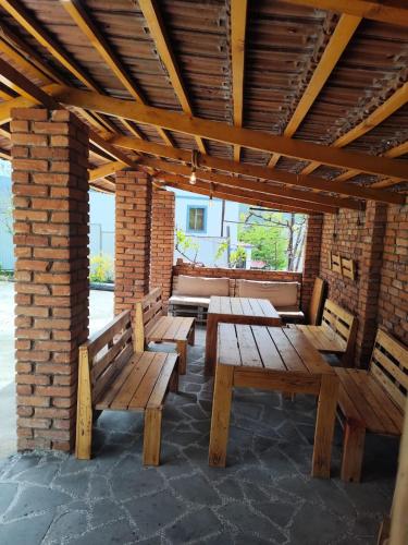 a group of wooden benches in a brick building at Hotel "Red House" in Akhaltsikhe
