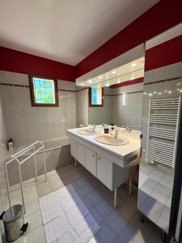 une salle de bain avec deux lavabos et un grand miroir dans l'établissement La maison de Camille, à Saillans