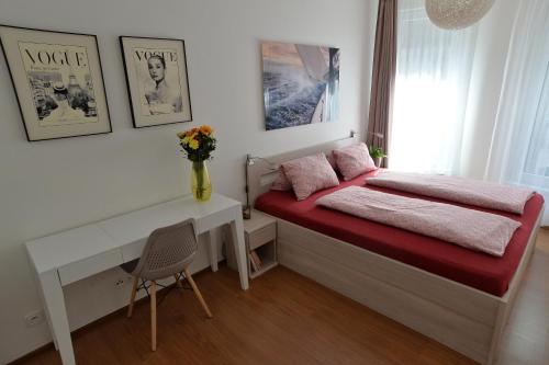a bedroom with a desk and a bed with pink sheets at Romantika na jezeře in Staré Splavy