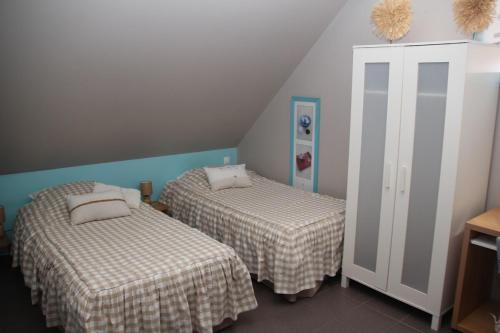 two beds in a room with a attic at studio à la campagne à Mastaing in Mastaing