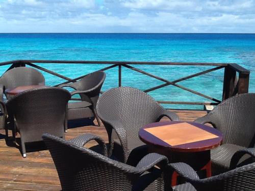 a table and chairs on a deck overlooking the ocean at Pension Turiroa " Chez Olga" in Avatoru