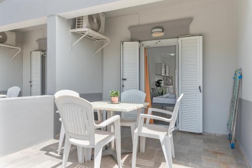 a dining room with white chairs and a table at Ilias Voula Studios in Panormos Kalymnos