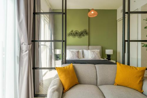 a bedroom with a bed and a couch with yellow pillows at Cozy One Bedroom Near Dubai Hills Mall in Dubai