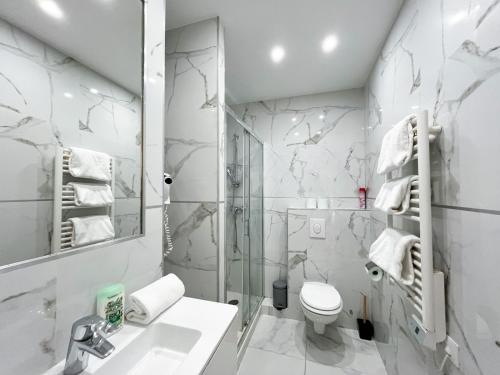 une salle de bain blanche avec des toilettes et un lavabo dans l'établissement Urban Flat 81 - Paris Luxe Sebastopol, à Paris