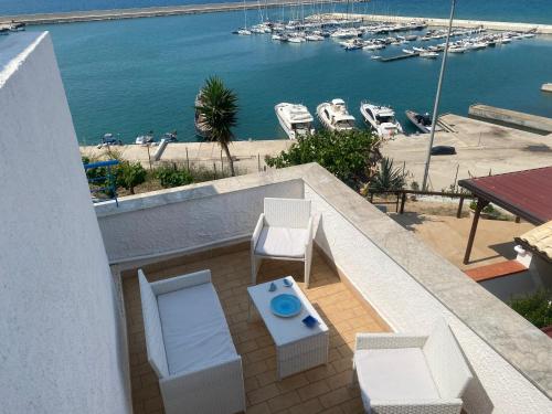 a balcony with a table and chairs and a harbor at Baia Marina Oasi in Balestrate