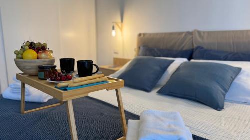 a bed with a table with a bowl of fruit on it at Monolocale per 2 nel Centro di Parma - Aurea Suite ! in Parma