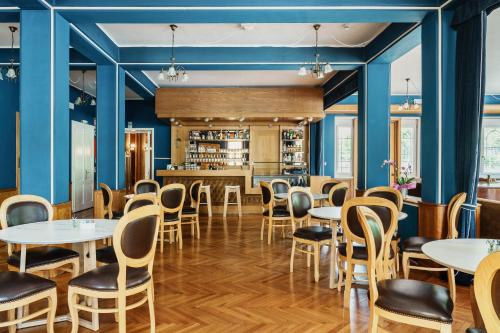 a restaurant with blue walls and tables and chairs at HOTEL AURONZO - outdoor basecamp in Auronzo di Cadore