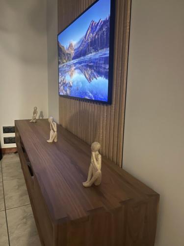 two small puppets sitting on top of a dresser in front of a tv at Les Colonnes d'Andrea in Nevers