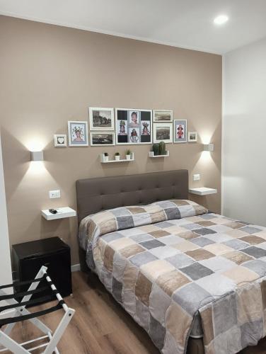 a bedroom with a large bed with pictures on the wall at Al Carmine Rooms in Milazzo