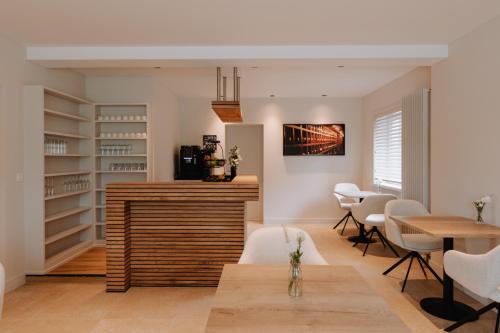 a dining room with a table and white chairs at Colliemolenhoeve 