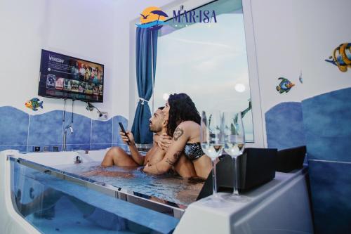 two people sitting in a bath tub looking at a cell phone at MAR-ISA Amalfi Coast in Vietri sul Mare