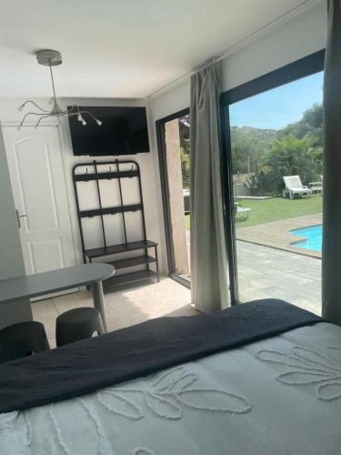 een slaapkamer met een bed en uitzicht op een patio bij En Plein cœur des calanques à 800 m de la mer in Le Rove