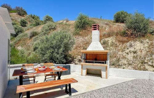 a patio with a fireplace and a table and benches at Evoikon in Liyiá
