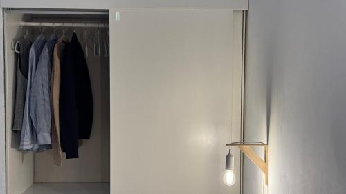 a closet with a sliding door with clothes in it at Monolocale per 2 nel Centro di Parma - Aurea Suite ! in Parma
