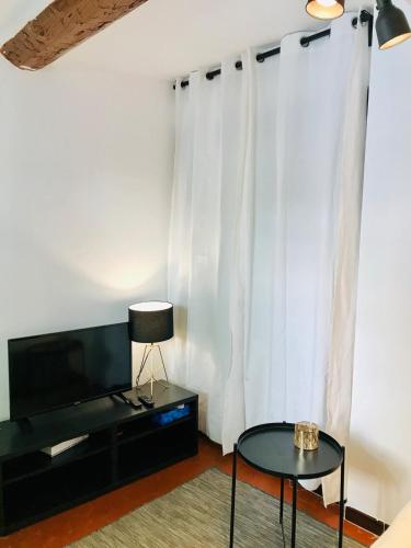 un salon avec une télévision et une table dans l'établissement Charming 1-bedroom Cours Sextius, à Aix-en-Provence