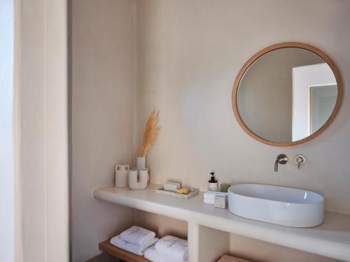 a white bathroom with a sink and a mirror at Salt Suites Paros in Naousa