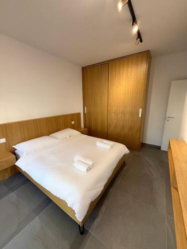 a bedroom with a bed with two towels on it at San Pietro Yard Apartment in Lalzit Bay