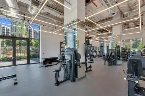 a gym with treadmills and elliptical machines at Chic Luna Apartments near Wembley Park by MySquare in London