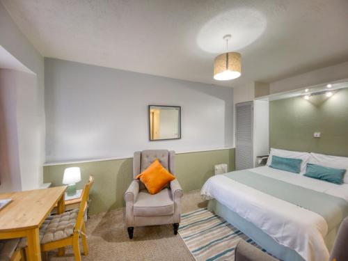 a bedroom with a bed and a desk and a chair at Apartment 8 - Large Studio Sea Front-Ground floor -Free Parking in Paignton