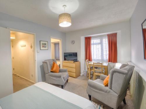 a bedroom with a bed and two chairs and a table at Apartment 8 - Large Studio Sea Front-Ground floor -Free Parking in Paignton
