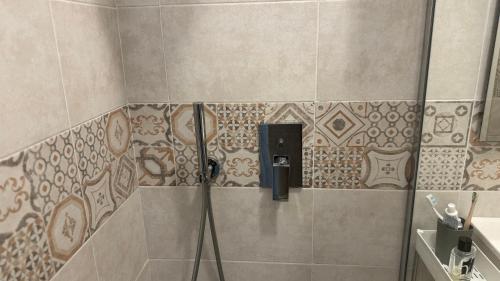 a shower in a bathroom with a tile wall at Monolocale per 2 nel Centro di Parma - Aurea Suite ! in Parma