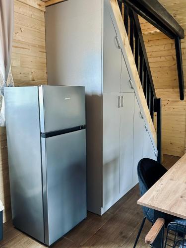 a refrigerator in a kitchen next to a staircase at Planinska Brvnara Zlatni Bor in Nedići