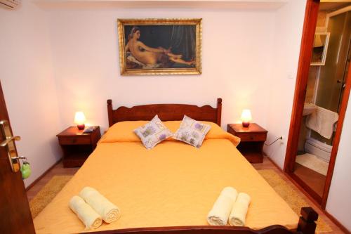 a bedroom with a large yellow bed with two lamps at Rooms & Studio Stipcic in Trogir
