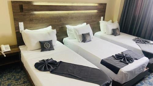 three beds in a hotel room with bows on them at Blue sky hotel in Oran