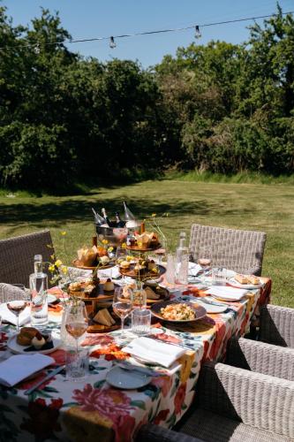 a long table with food and wine glasses on it at Retreat East in Ipswich