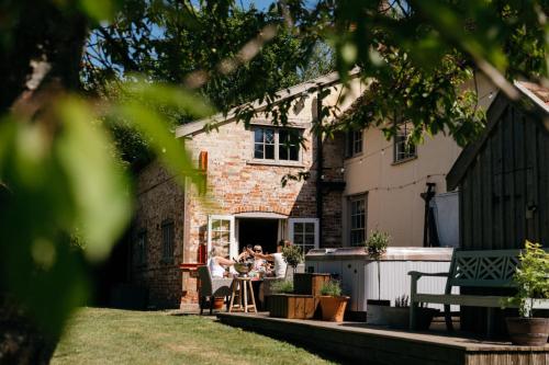 two people sitting at a table outside a house at Retreat East in Ipswich
