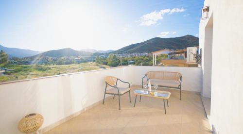 a balcony with two chairs and a table at Rena & Agua Apartments in Siniscola
