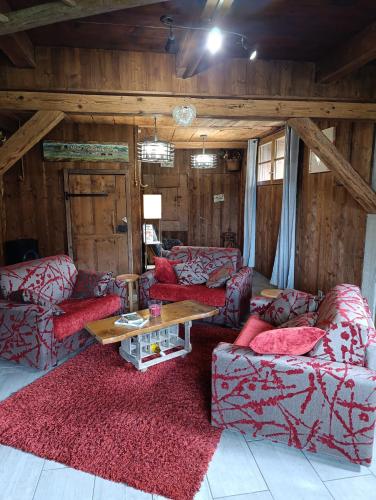 un salon avec des canapés rouges et une table dans l'établissement Chalet d alpage en montagne L Atray Des Neiges 3 étoiles multipass gratuit, à Morzine