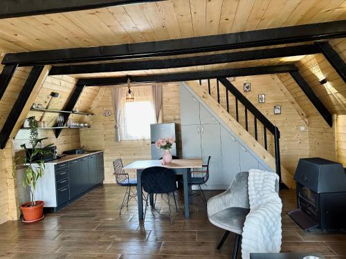 a kitchen with a table and chairs in a room at Planinska Brvnara Zlatni Bor in Nedići