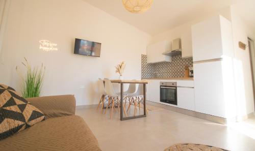 a living room with a couch and a kitchen at Rena & Agua Apartments in Siniscola